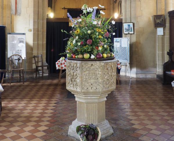 Flowers and produce on the font